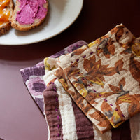 a stack of differently coloured and design cloth napkins from hkliving which sit so nicely togther despite the range of purples, oranges, pinks, and browns