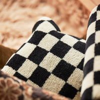 close up of the fluffy texture of the blacka nd white check deisgned cushion