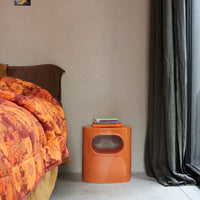 a bedroom with an orange purple quilt on a bed and the glossy orange bed side table of the hkliving design space side table