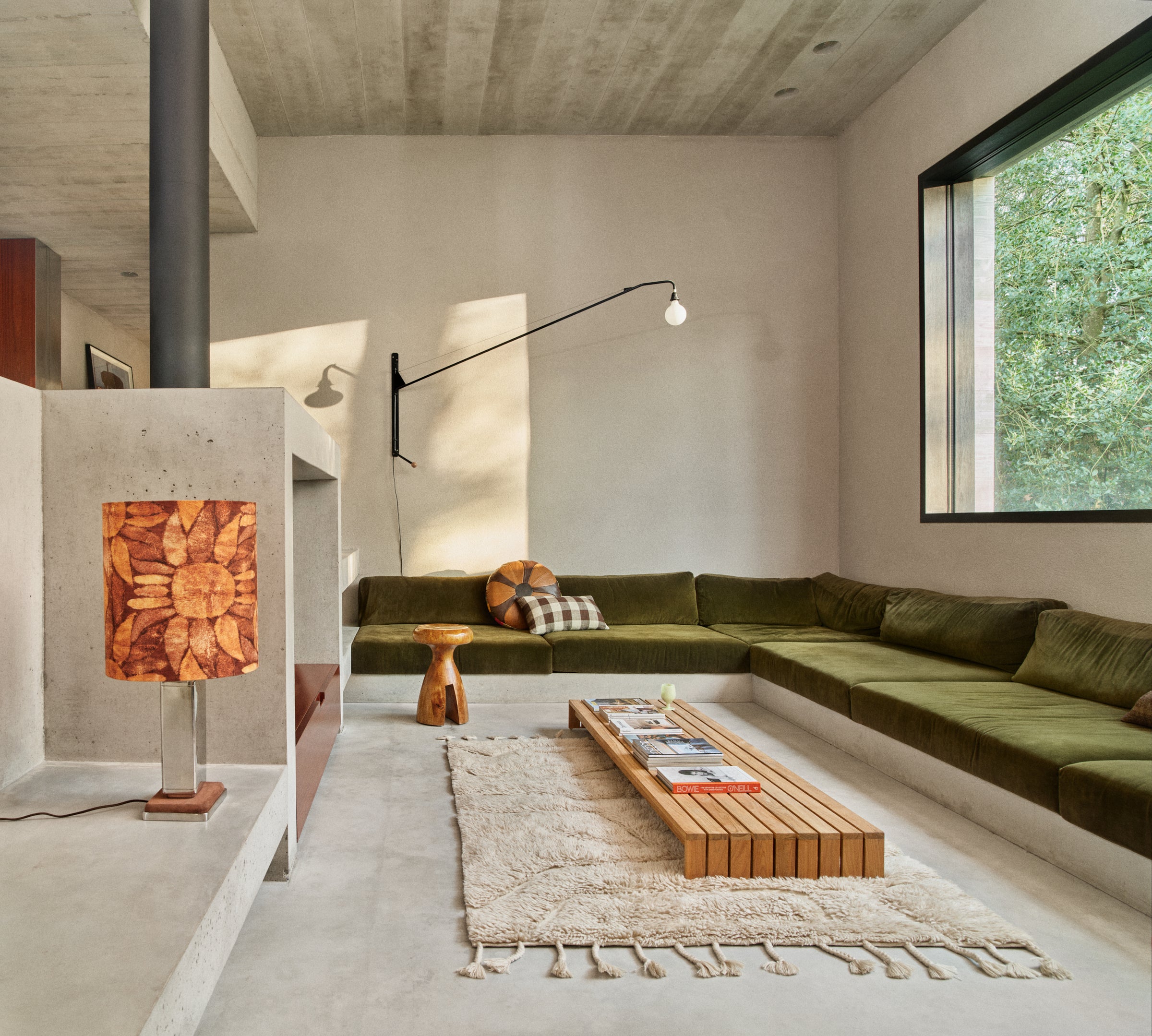 HKLIVING wool rug limitless in cream in a living room setting with a green corner sofa, wooden stool and table lamp