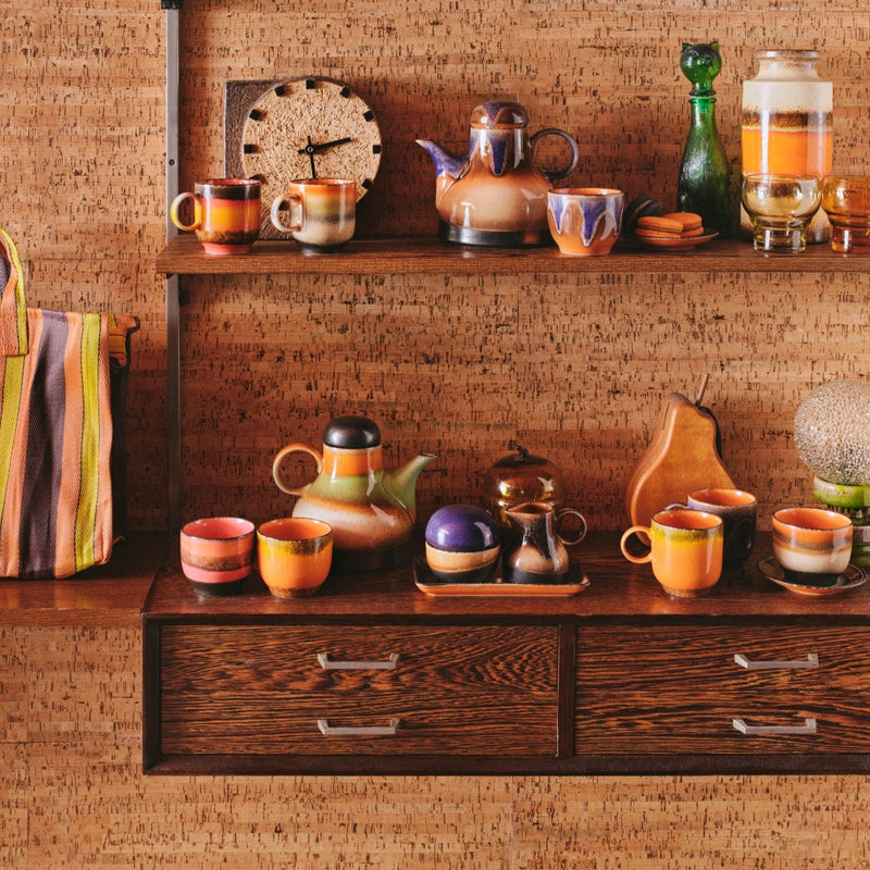 mixture of 70s ceramics collection from hkliving on a wooden sideboard with a shelf. above