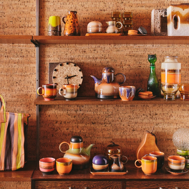 joyful 70s crockery from hkliving covering wooden sideboard and shelves