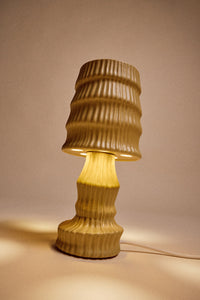 HKLIVING ochre ribbed ceramic table lamp lit, glowing warmly against a soft pink backdrop