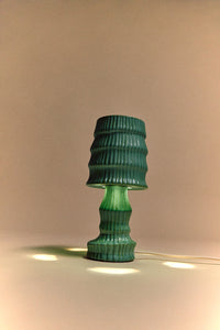 HKLIVING petal green ribbed ceramic table lamp lit, glowing against a warm taupe backdrop