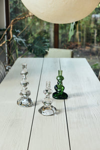 Nienke Sikkema glass candle holders in clear and green on a long white dining table