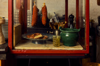 70s Ceramics Footed Fruit Bowl in Noise by HKLIVING holding a pretzel, displayed in a vintage red-framed deli cabinet