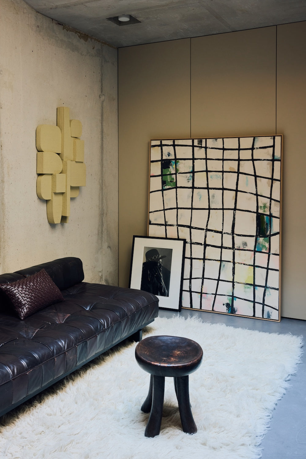Wired framed canvas wall art by HKLIVING leaning against a concrete wall beside a leather sofa and framed portrait