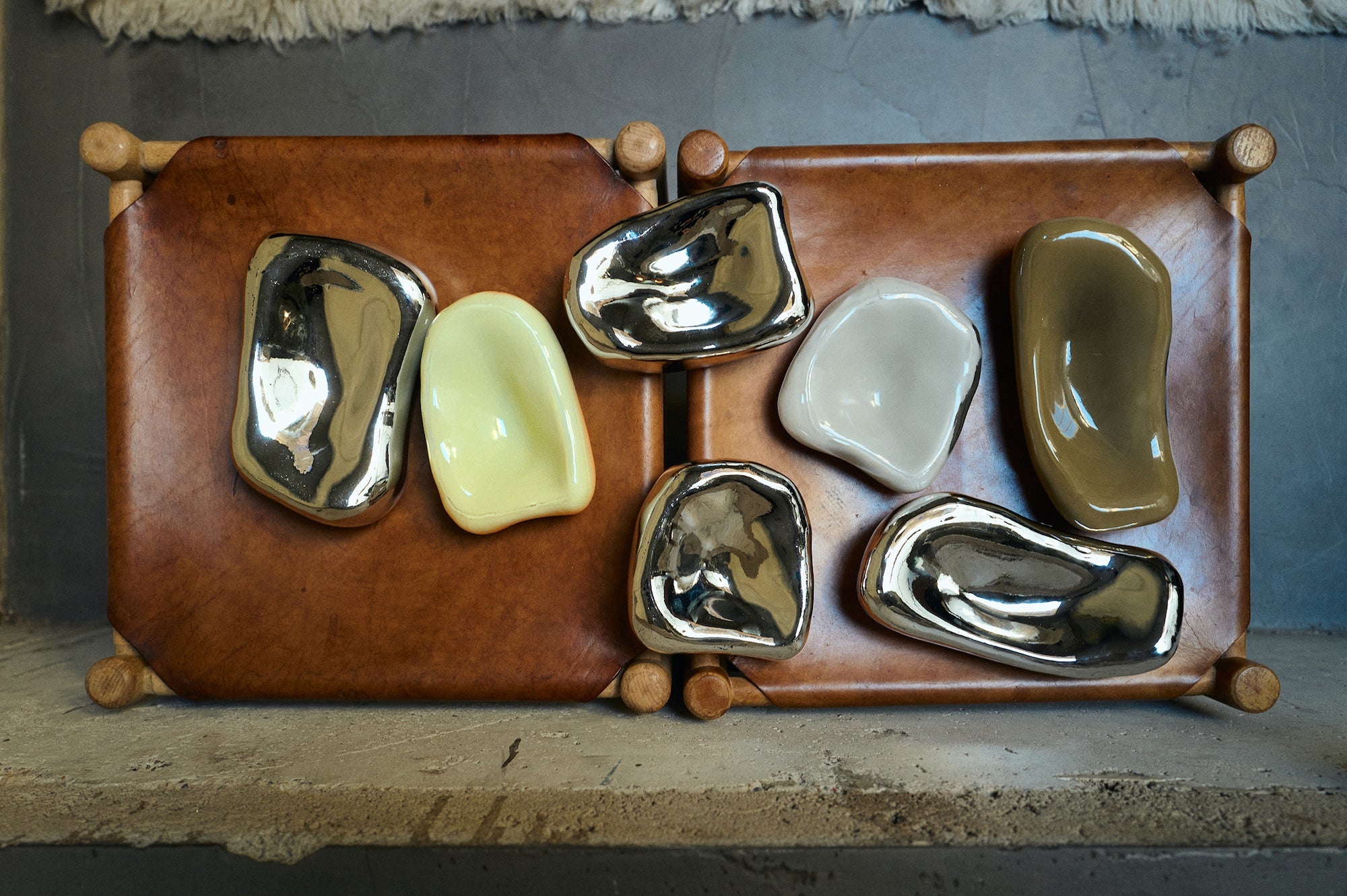Set of ceramic stones in various colors on a wooden stand against a textured wall.