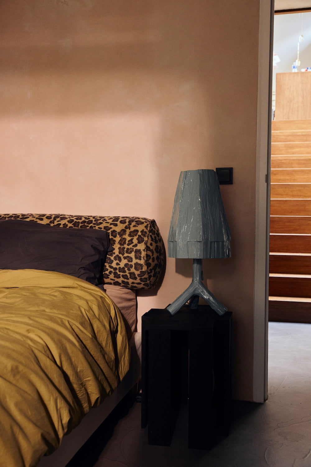 Teun Zwets for HKLIVING Sky Blue table lamp lit, styled on a black cabinet against a pink bedroom wall
