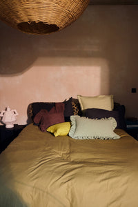 HKLIVING mint felt cushion with ruffled edge styled on a bed with mustard bedding and leopard print bolster