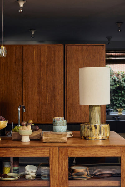 large hkliving ceramic lamp base styled with a natural silk cylinder shade, lit, against a dark backdrop