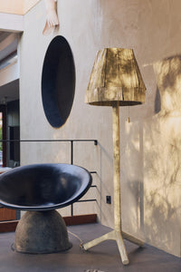 Teun Zwets for HKLIVING Overcast floor lamp styled beside a black leather chair in a sunlit concrete interior