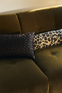 Chocolate brown woven faux leather cushion styled on an olive velvet sofa