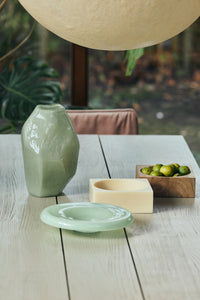 Nienke Sikkema for HKLIVING jade gemstone vase styled on a dining table with a small dish and wooden bowl of limes