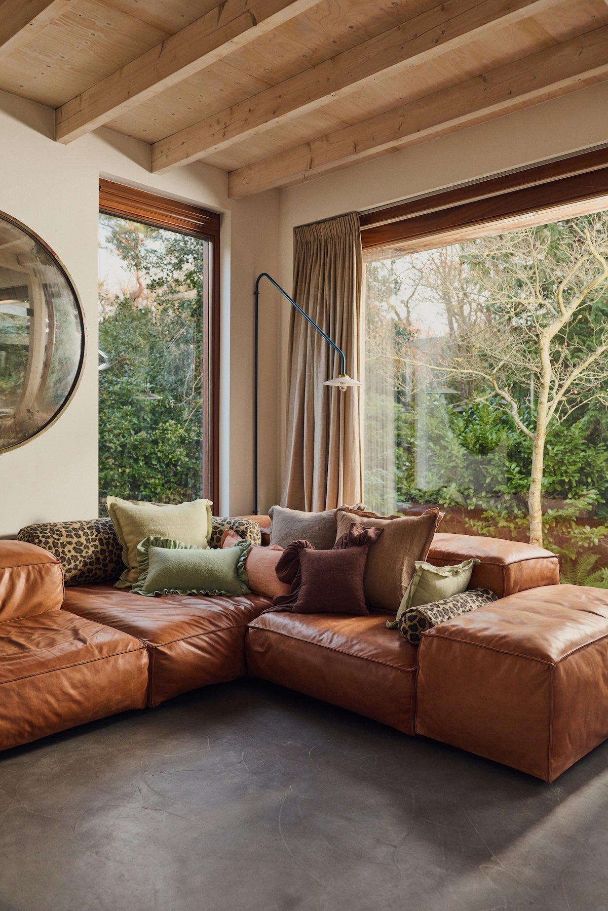 Chestnut brown ruffle cushion styled on a tan leather corner sofa