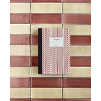 Red patterned notebook styled on ceramic tiled background