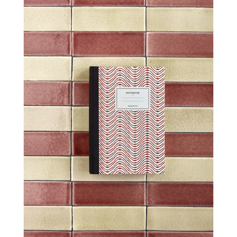 Red patterned notebook styled on ceramic tiled background