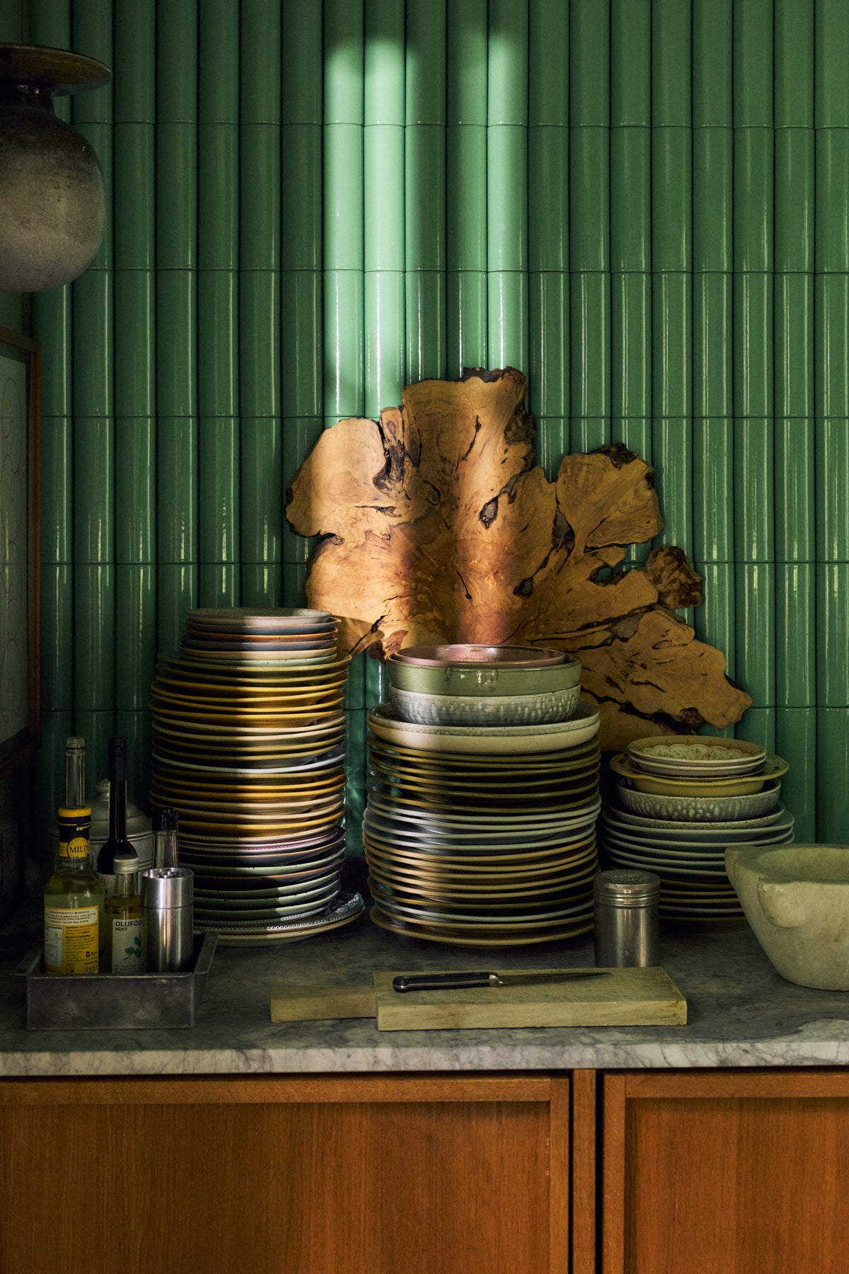 Stacks of HKLIVING Chef Ceramics plates on a kitchen worktop against green tiles