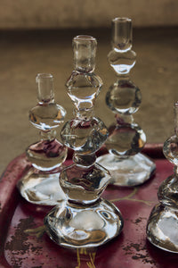 Close-up of clear Nienke Sikkema glass candle holders on a red tray