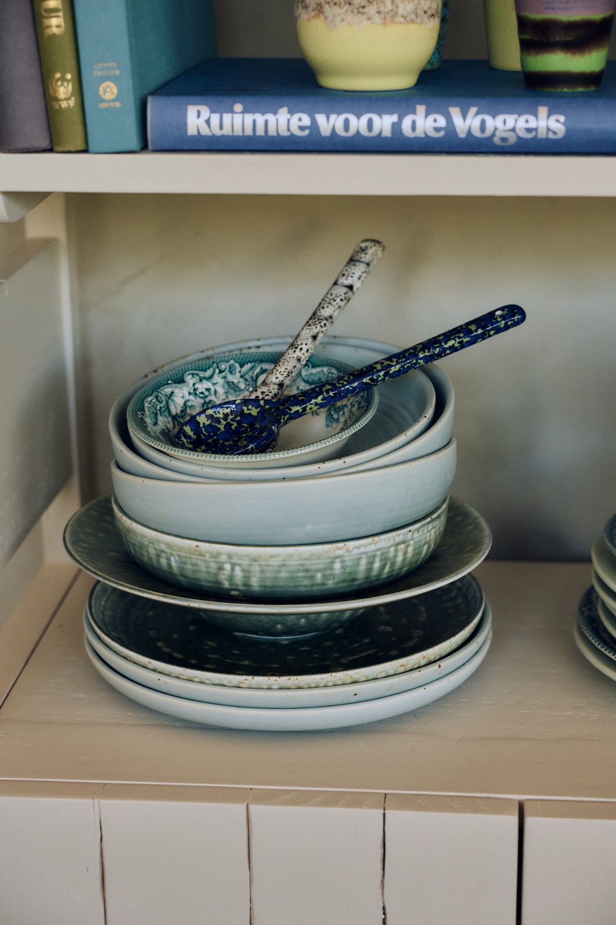 Stacked HKLIVING Chef Ceramics bowls and plates on a shelf with books