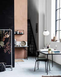House Doctor Acorn pendant light hanging against a dark background with dried flowers