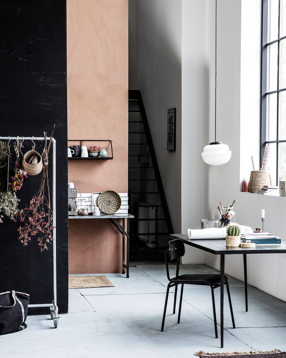 House Doctor Acorn pendant light hanging against a dark background with dried flowers