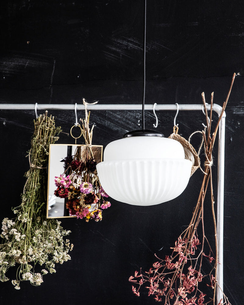 House Doctor Acorn white pendant light above a black desk in a loft-style workspace