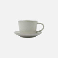 cup and suacer in white with little brown speckles and a generous handle on the cup