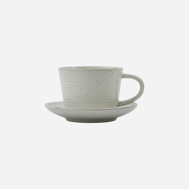 cup and suacer in white with little brown speckles and a generous handle on the cup