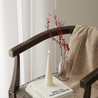 Decorative setup with a vase of red berries, candle, and books on a wooden chair.