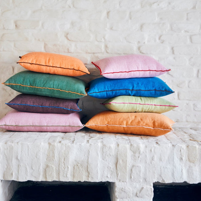 2 stacks of differently coloured linen cushions in nordic style by hkliving with green, blue, orange, pink, burgundy, and other colours