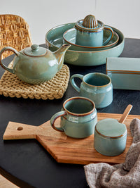 pixie jar with lid and spoon styled with matching green stoneware mugs and tea set
