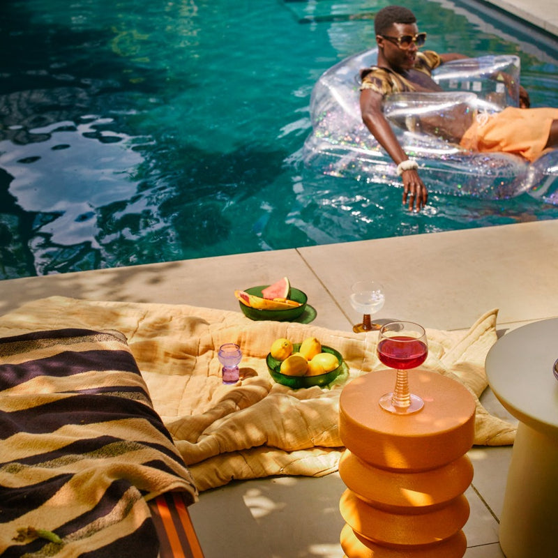 pool side scene with hkliving blankets and end tables