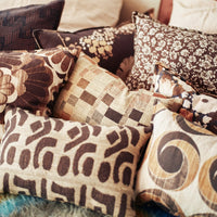 a selection of cushions in a similar colour palette of browns, beiges, and creams