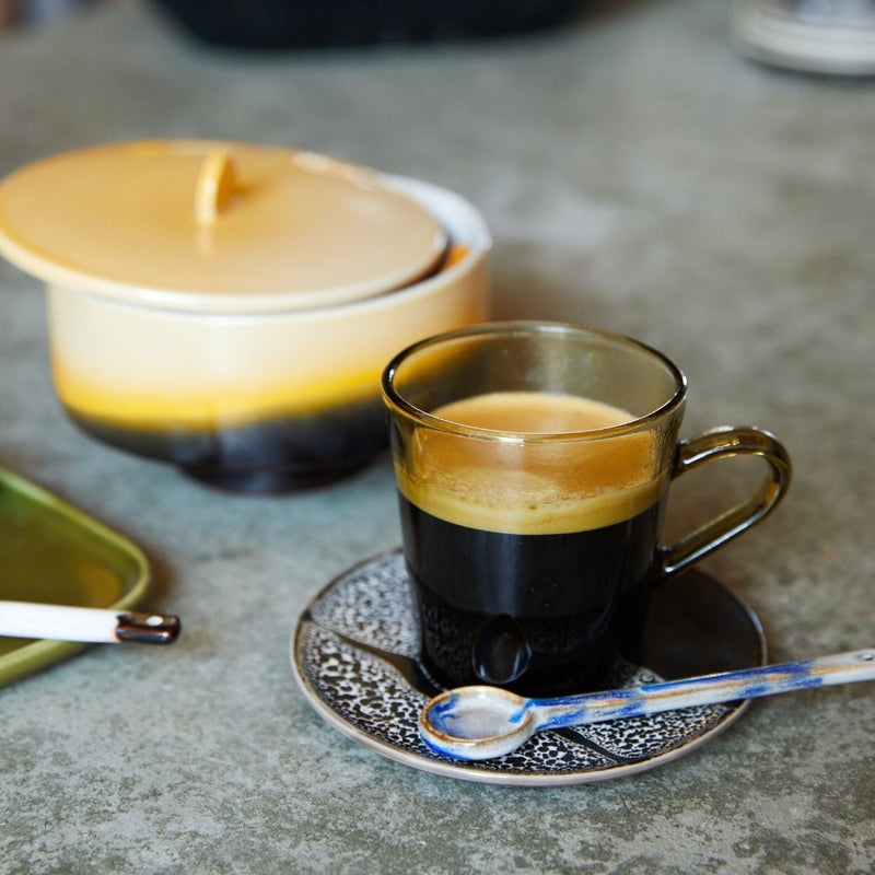 ceramic spoon on a 70s ceramic saucer from hkliving and a brown glass coffee mug