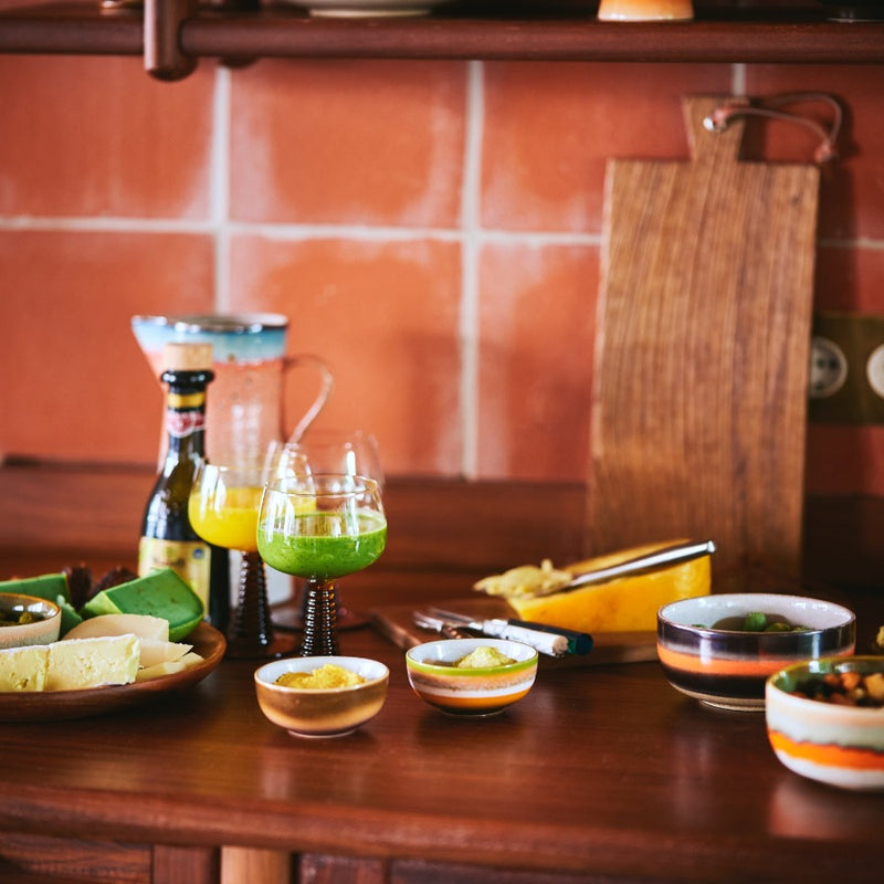 a collection of hkliving crockery on a kitchen worktop in a multitude of bright and joyful colours and commbinations