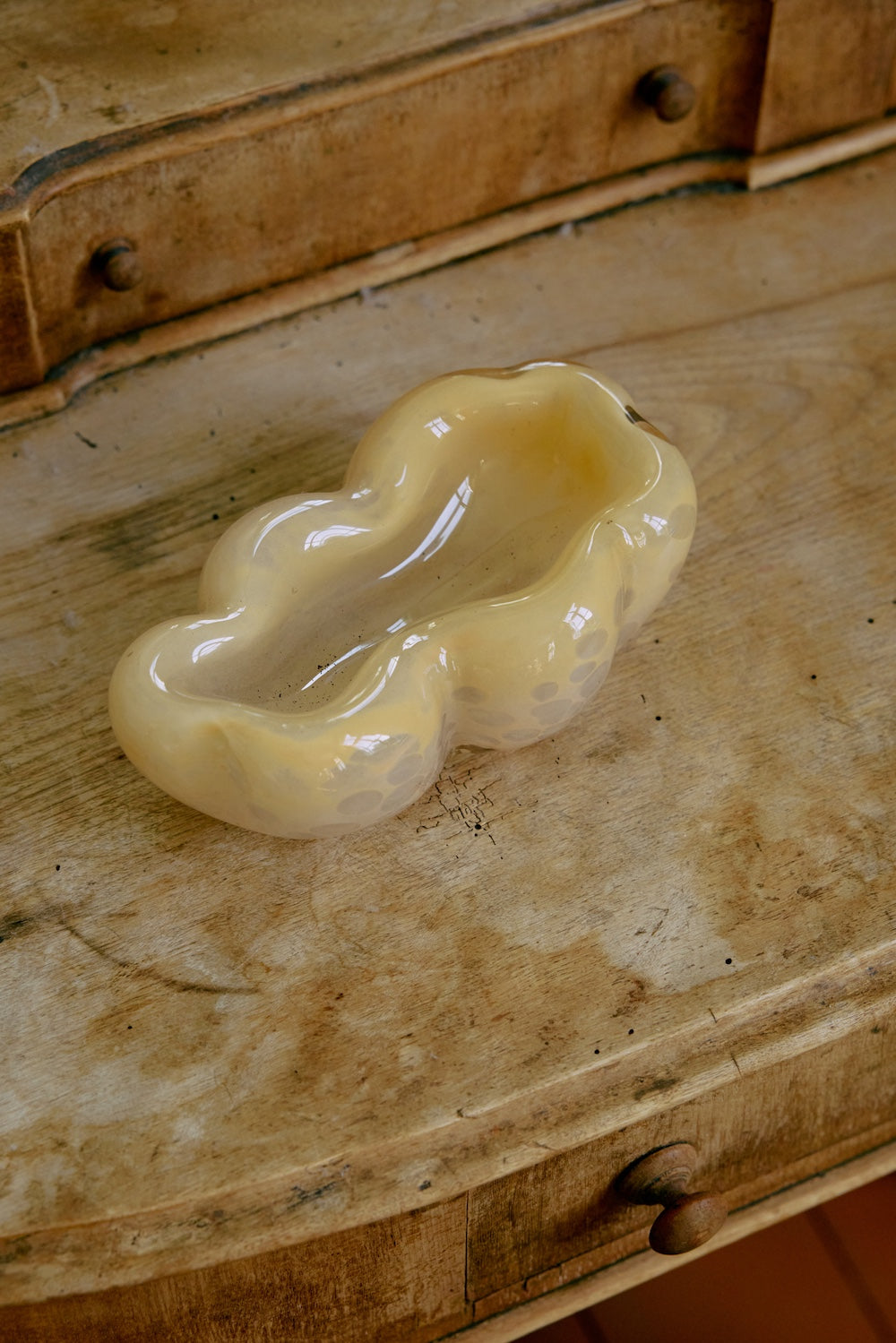 The HKLIVING oyster glass bowl displayed on a weathered wooden dresser, styled with a small wooden dish beside it