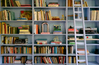 chrome stainless steel arch sculpture by HKLIVING styled on large blue bookshelf
