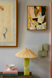 Sage green Levels wall sculpture styled beside abstract art and a yellow table lamp