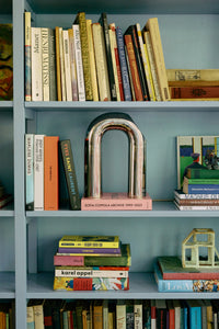close view of HKLIVING chrome arch sculpture displayed among books
