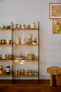 70s Ceramics teapot in Slush shown on a glass shelf alongside a pink teapot and other ceramics from HKLIVING's collection, with artwork on the wall behind