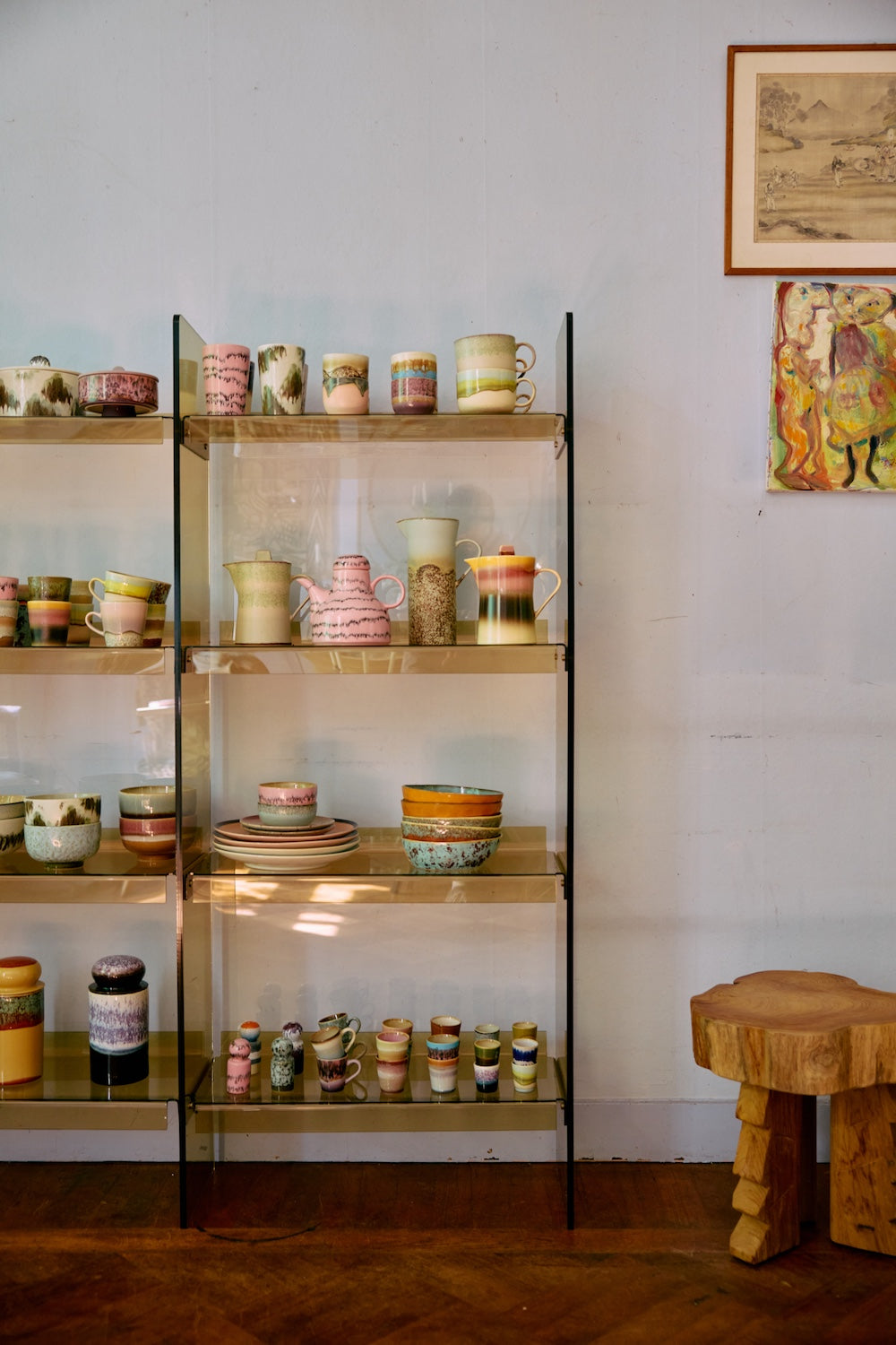 70s Ceramics teapot in Slush shown on a glass shelf alongside a pink teapot and other ceramics from HKLIVING's collection, with artwork on the wall behind