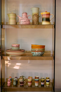 70s Ceramics pasta bowls in Patina displayed on a glass shelving unit alongside jugs, plates and cups from HKLIVING's collection
