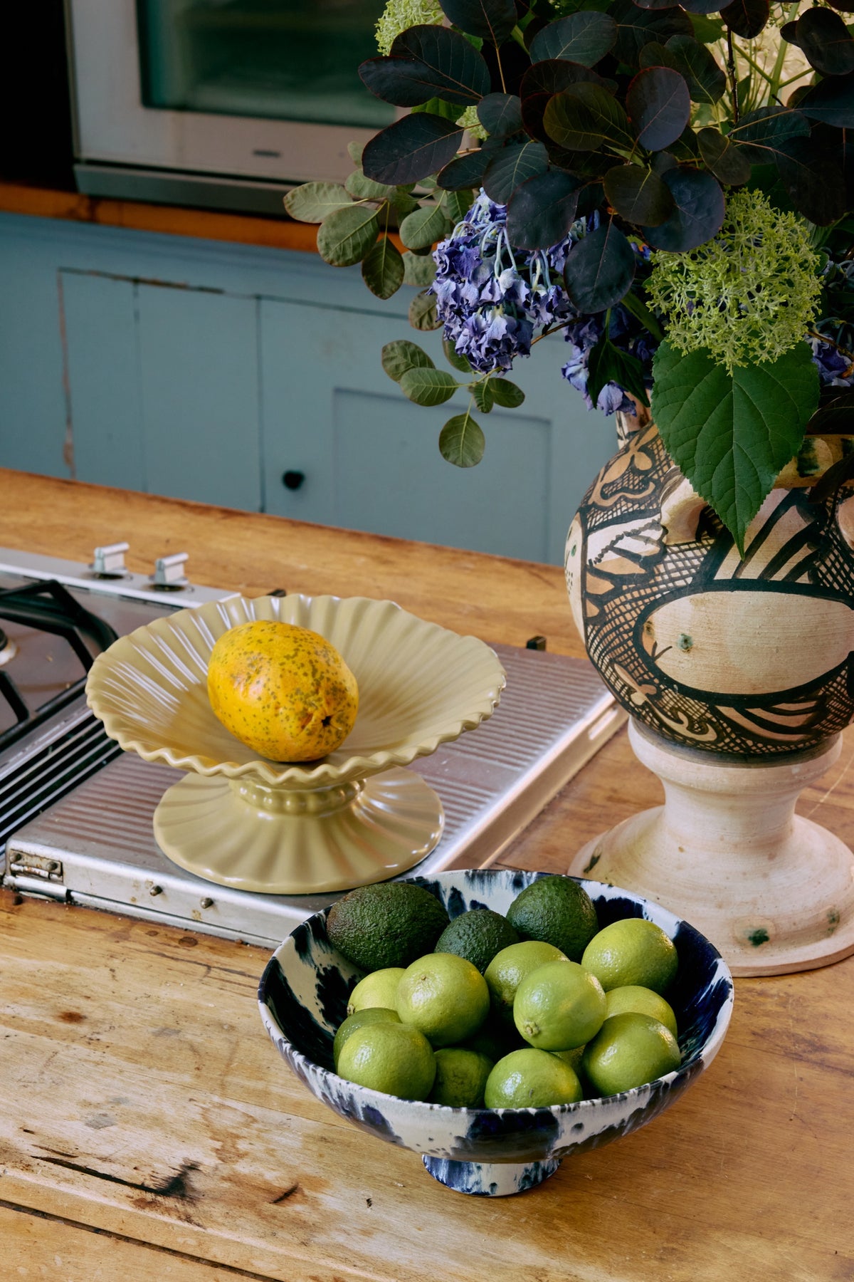indigo and white polyresin hkliving bowl with limes on a table in a kitchen