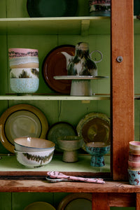 HKLIVING 70s Ceramics bowls, plates and a coffee pot displayed on the shelves of a green painted dresser