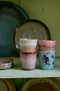 The HKLIVING Futurism ristretto mugs displayed on the bottom shelf of a tall glass and brass unit, alongside jugs, bowls and plates from the 70s ceramics collection