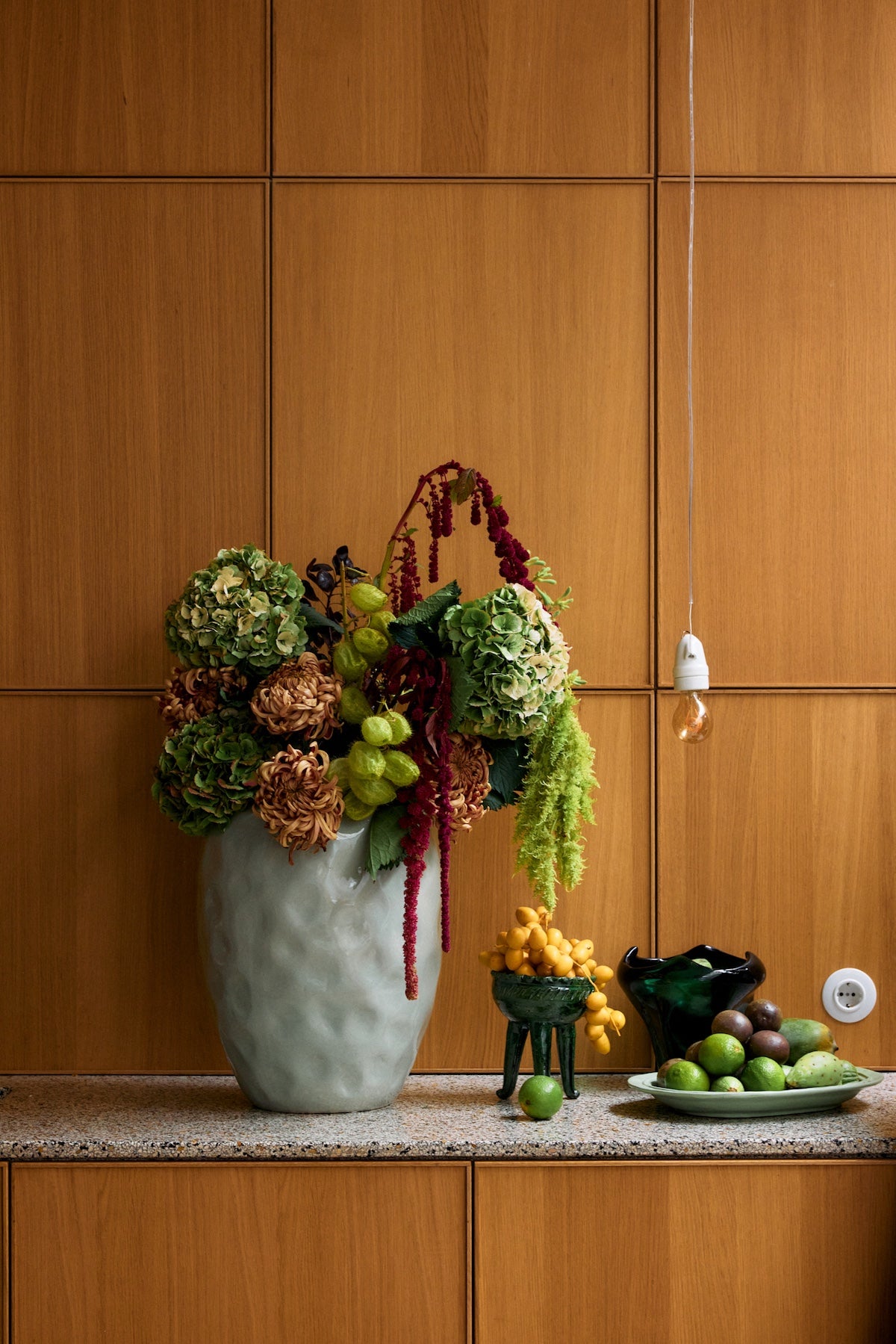 Close-up of HKLIVING pale mint floor vase filled with dried hydrangeas and amaranthus on a wooden panelled background