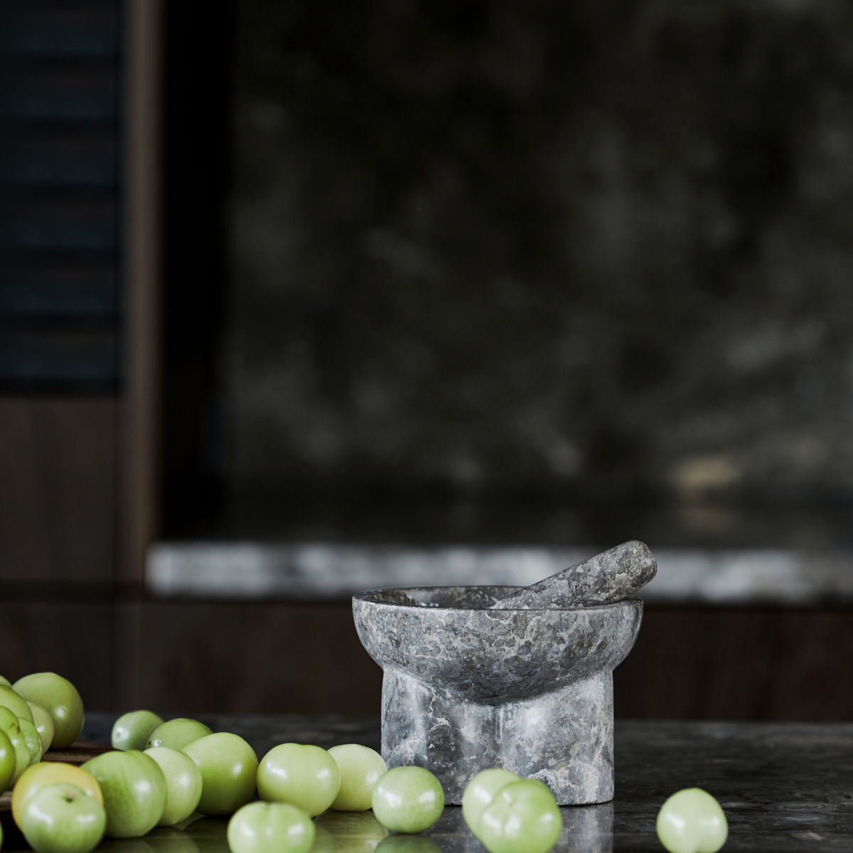 House Doctor Kulti marble mortar and pestle styled on a dark stone counter with fresh green grapes