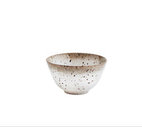 small speckled stoneware bowl stacked with matching reactive glaze tableware
