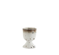 stoneware egg cup with white glaze and brown speckled detailing

